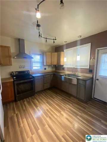 a kitchen with stainless steel appliances granite countertop a sink a stove and a refrigerator