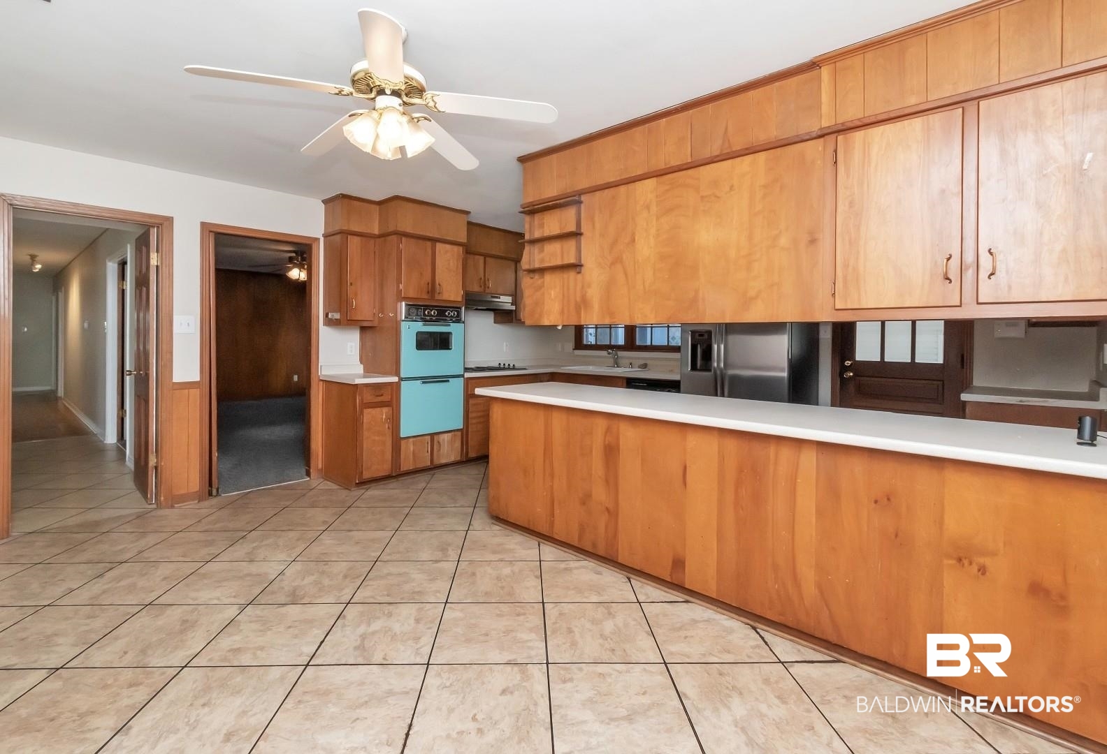 4543 Kingsway Drive Mobile, AL 36608 - Photo 12 of 28 Kitchen with light countertops, a peninsula, brown cabinets, and stainless steel fridge with ice dispenser