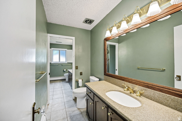 1365 Sumac Drive Logan, UT 84321 - Photo 30 of 66 Bathroom vanity featuring a light-toned countertop with integrated sink, wood-framed mirror, and brass-finish fixtures