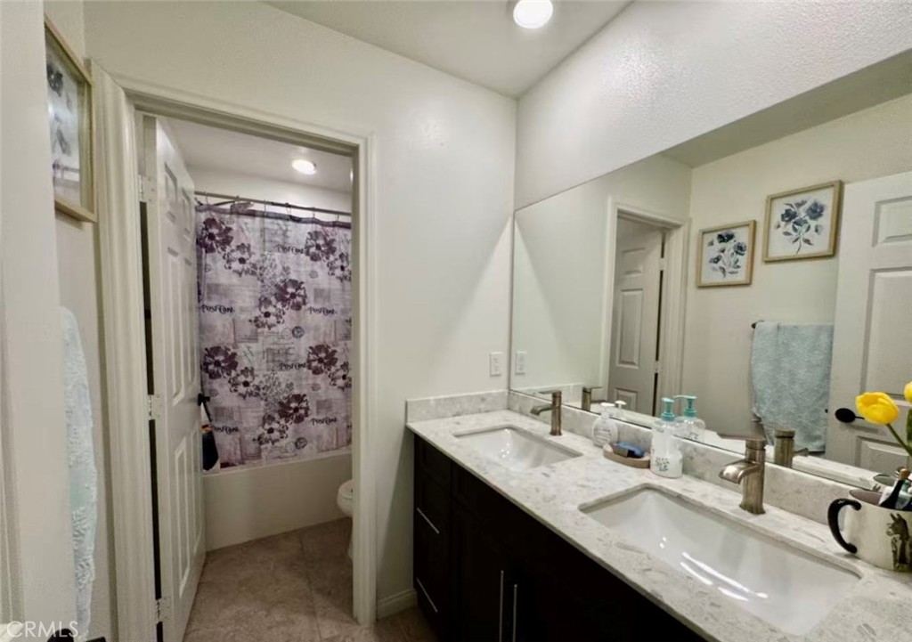 10664 Busch Street Spring Valley, CA 91978 - Photo 6 of 14 a bathroom with double vanity sinks a shower and a mirror