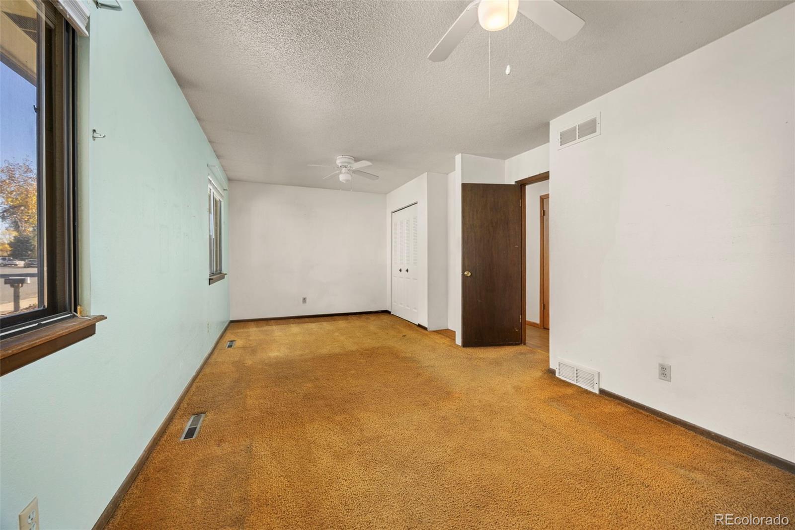1006 Shortline Drive Fort Lupton, CO 80621 - Photo 13 of 33 an empty room with a ceiling fan and window