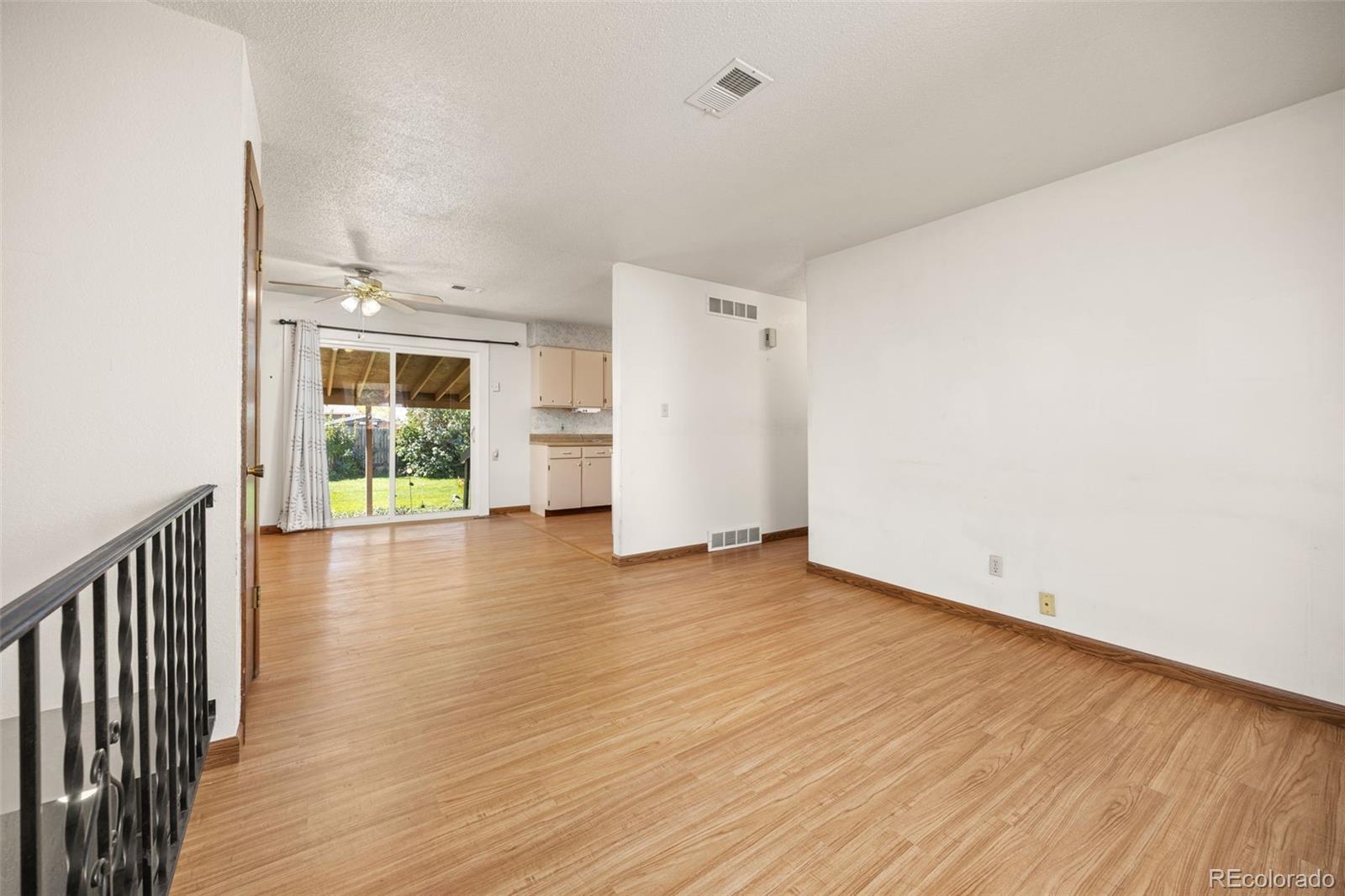 1006 Shortline Drive Fort Lupton, CO 80621 - Photo 6 of 33 an empty room with wooden floor and windows