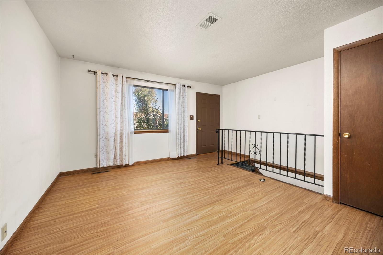 1006 Shortline Drive Fort Lupton, CO 80621 - Photo 8 of 33 a view of an empty room with wooden floor