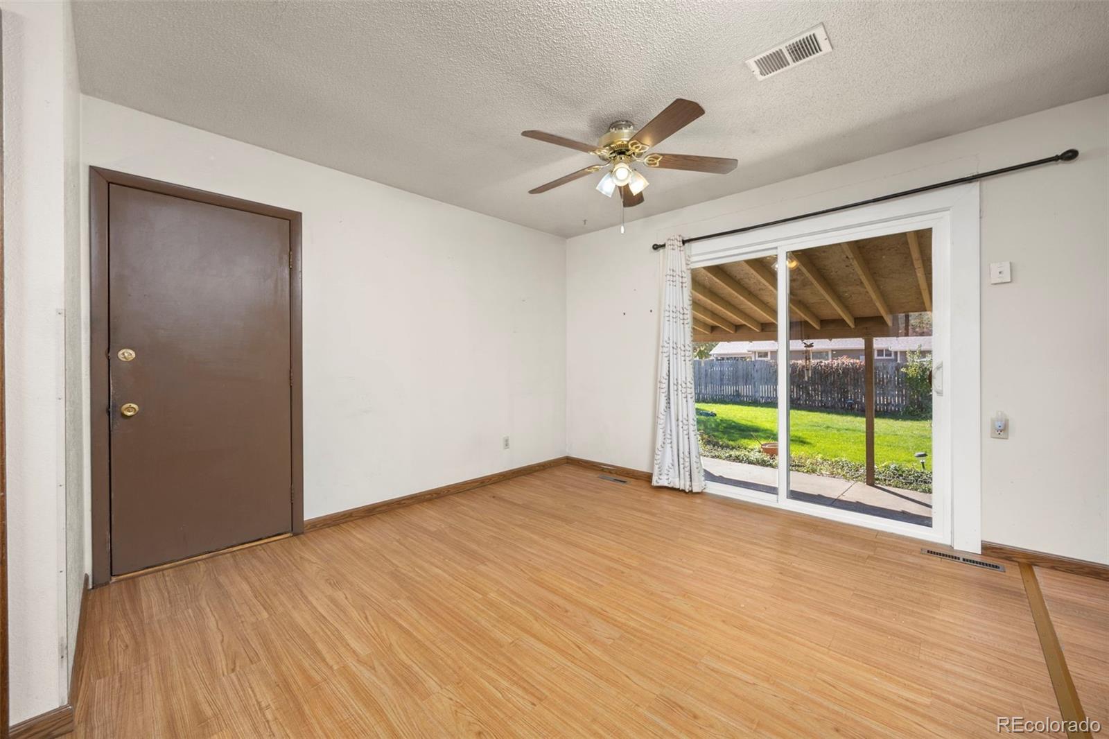 1006 Shortline Drive Fort Lupton, CO 80621 - Photo 9 of 33 a view of an empty room with a window and wooden floor