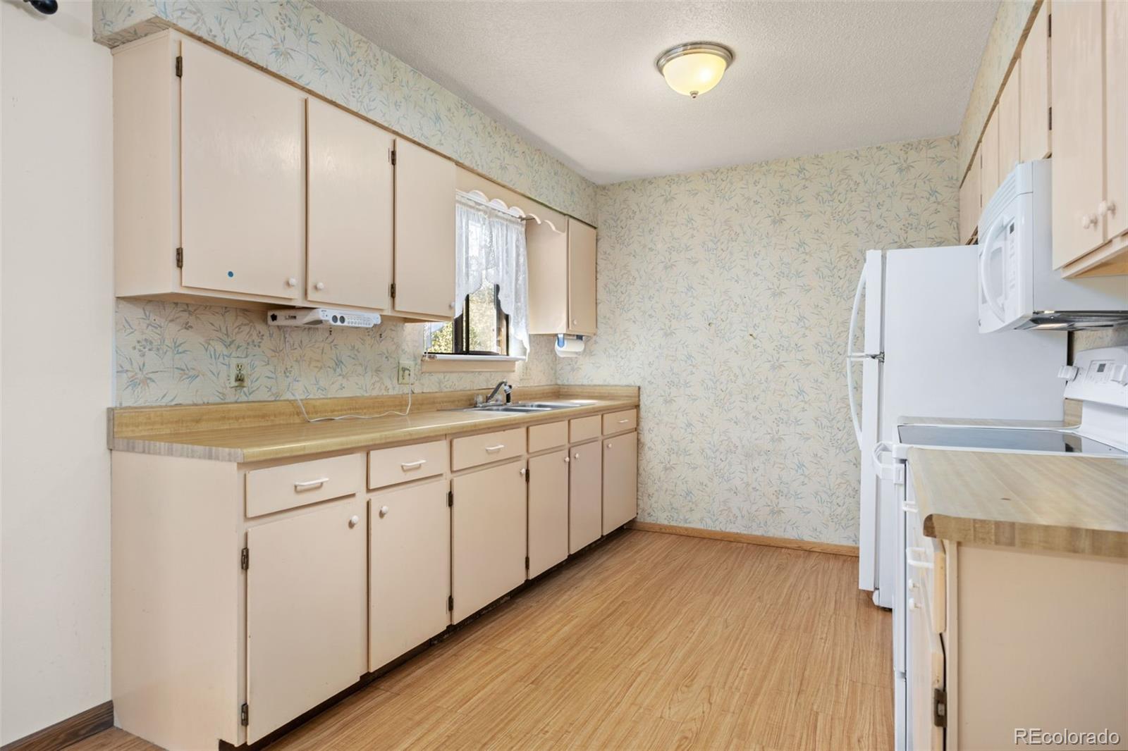1006 Shortline Drive Fort Lupton, CO 80621 - Photo 10 of 33 a kitchen with sink cabinets and window