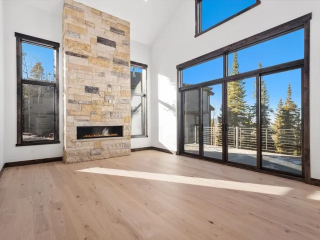 an empty room with wooden floor and fireplace