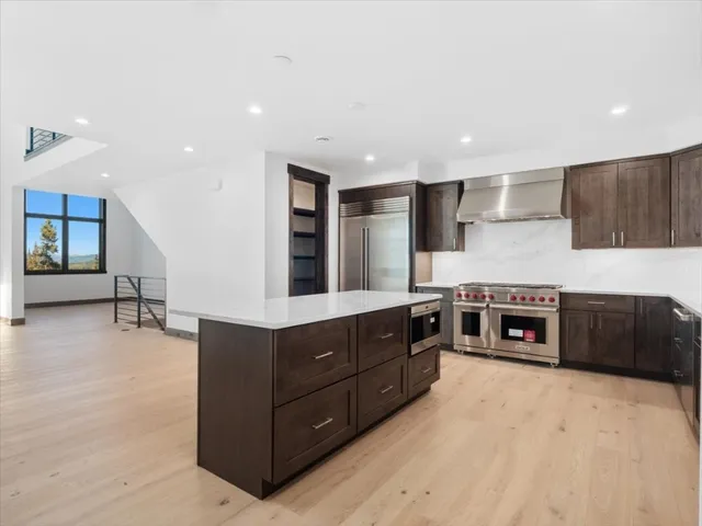 a kitchen with stainless steel appliances granite countertop a stove a sink and a microwave