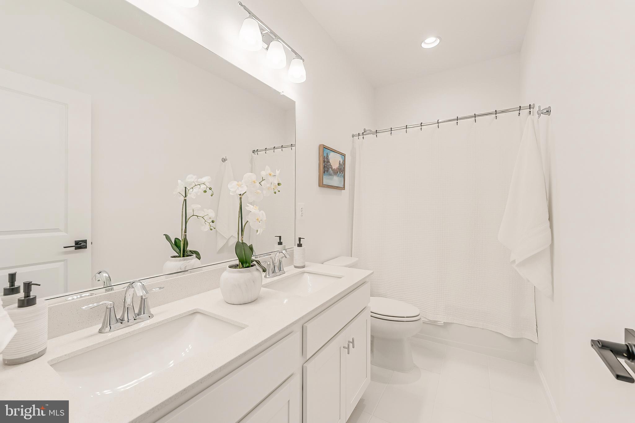 18260 Moss Garden Road Dumfries, VA 22026 - Photo 49 of 97 a bathroom with a double vanity sink toilet and a mirror