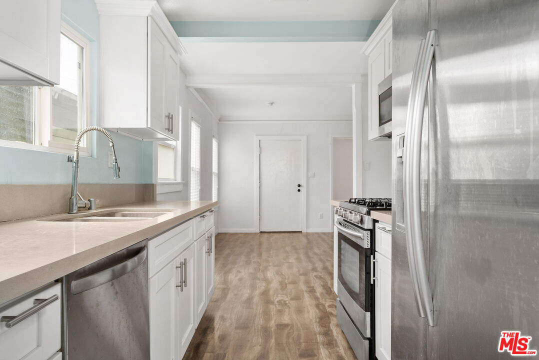 2738 Cloverdale Avenue Los Angeles, CA 90016 - Photo 15 of 17 a kitchen with a sink stove and refrigerator