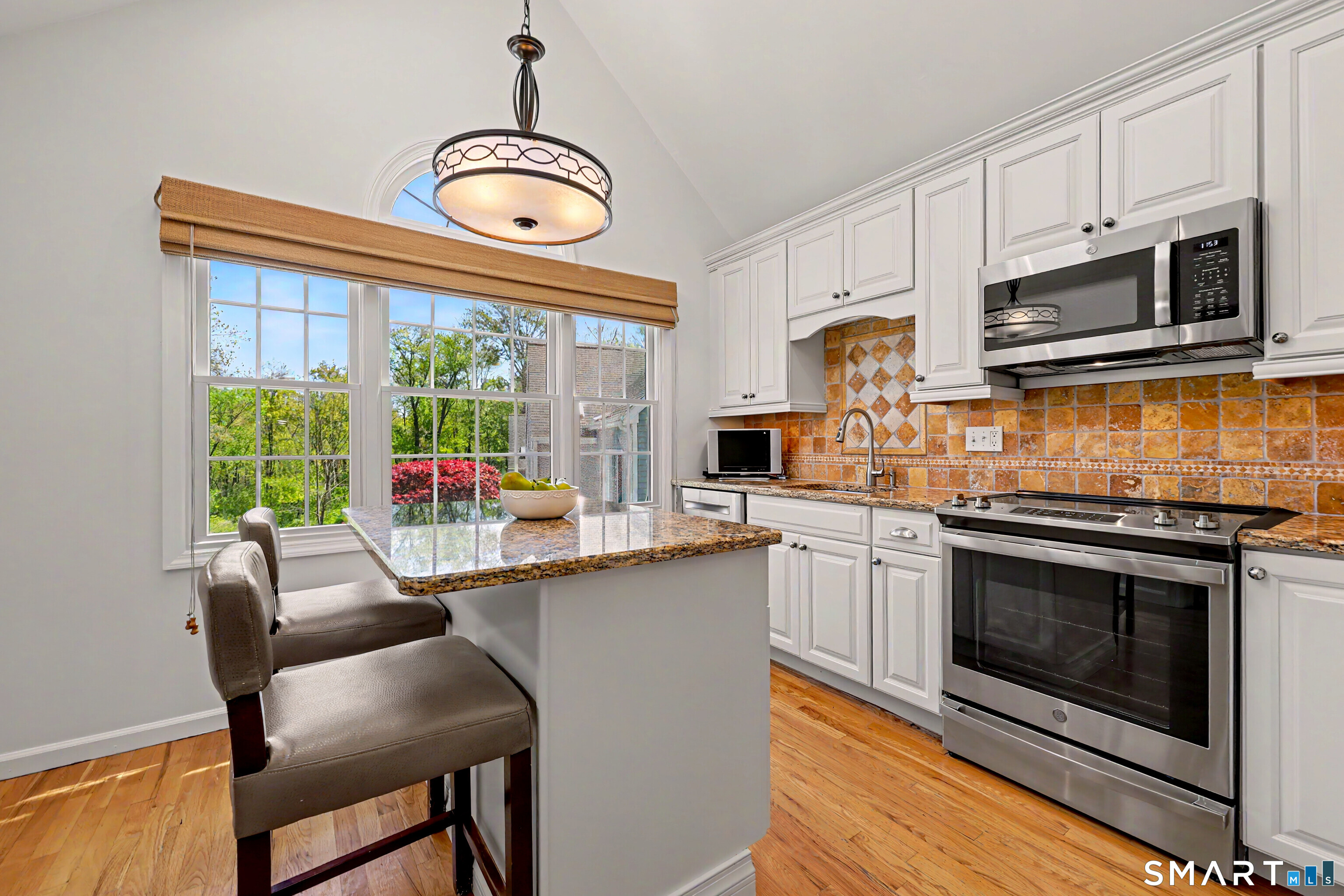 120 Prospect Street, Unit 46 Ridgefield, CT 06877 - Photo 15 of 36 a kitchen with stainless steel appliances a stove a microwave sink and cabinets