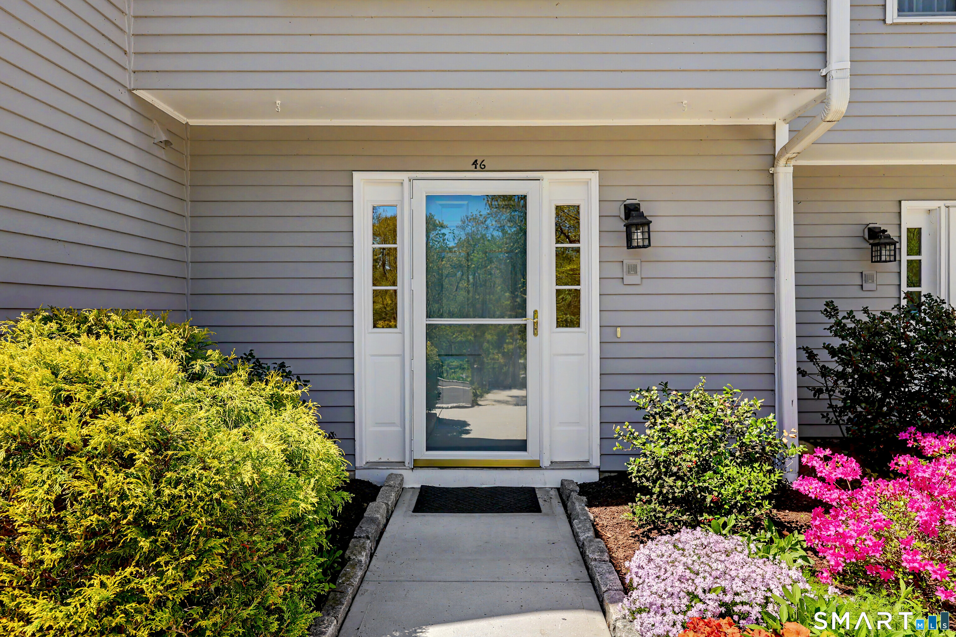 120 Prospect Street, Unit 46 Ridgefield, CT 06877 - Photo 4 of 36 a front view of a house with a flower garden