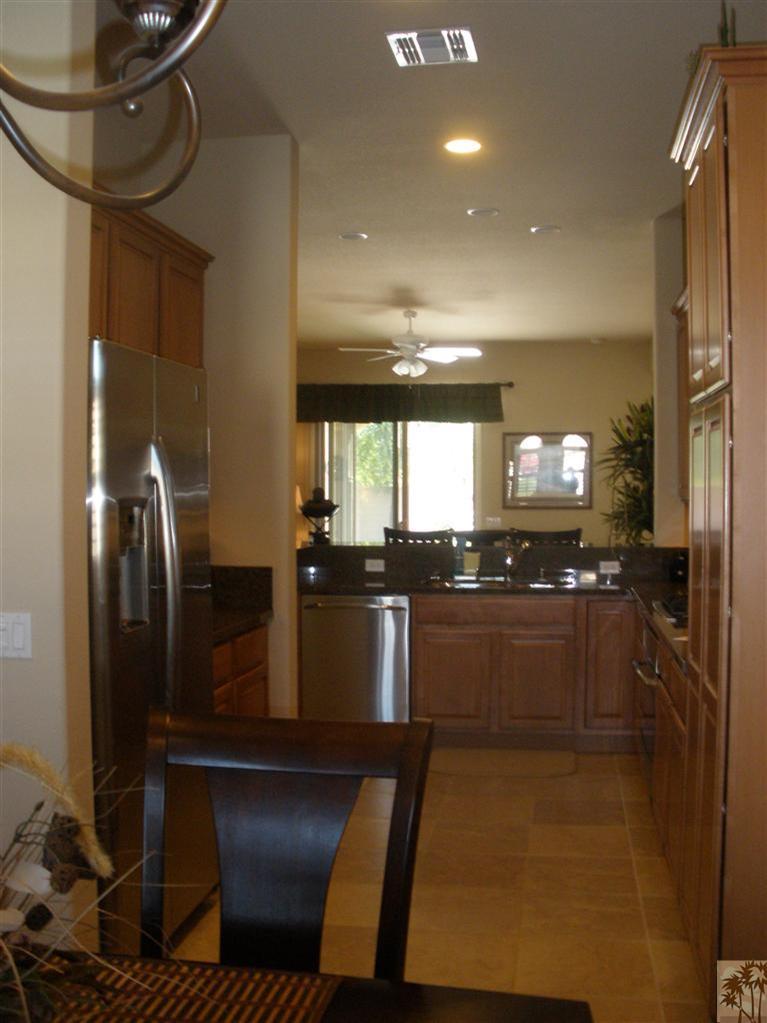 81673 Avenida Alturas Indio, CA 92203 - Photo 6 of 17 a kitchen with stainless steel appliances kitchen island granite countertop a refrigerator a stove and a sink with wooden floor