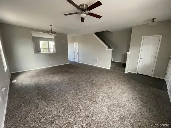 an empty room with a ceiling fan and a window
