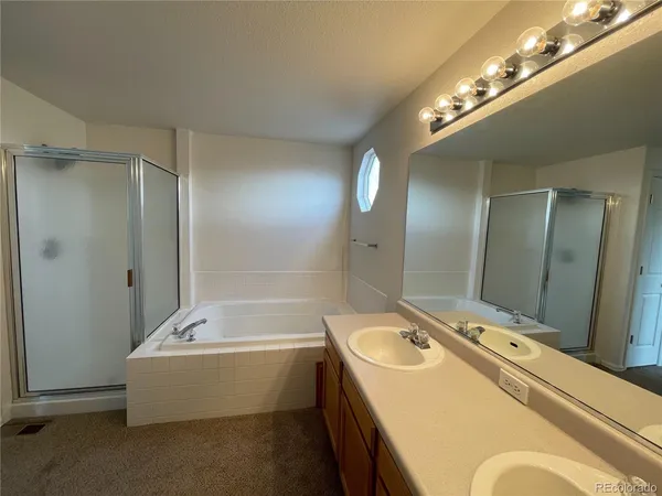 a bathroom with a tub a sink and mirror
