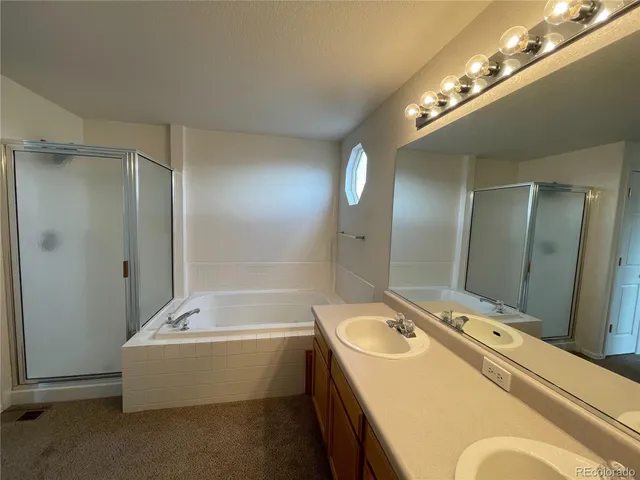 a bathroom with a tub a sink and mirror