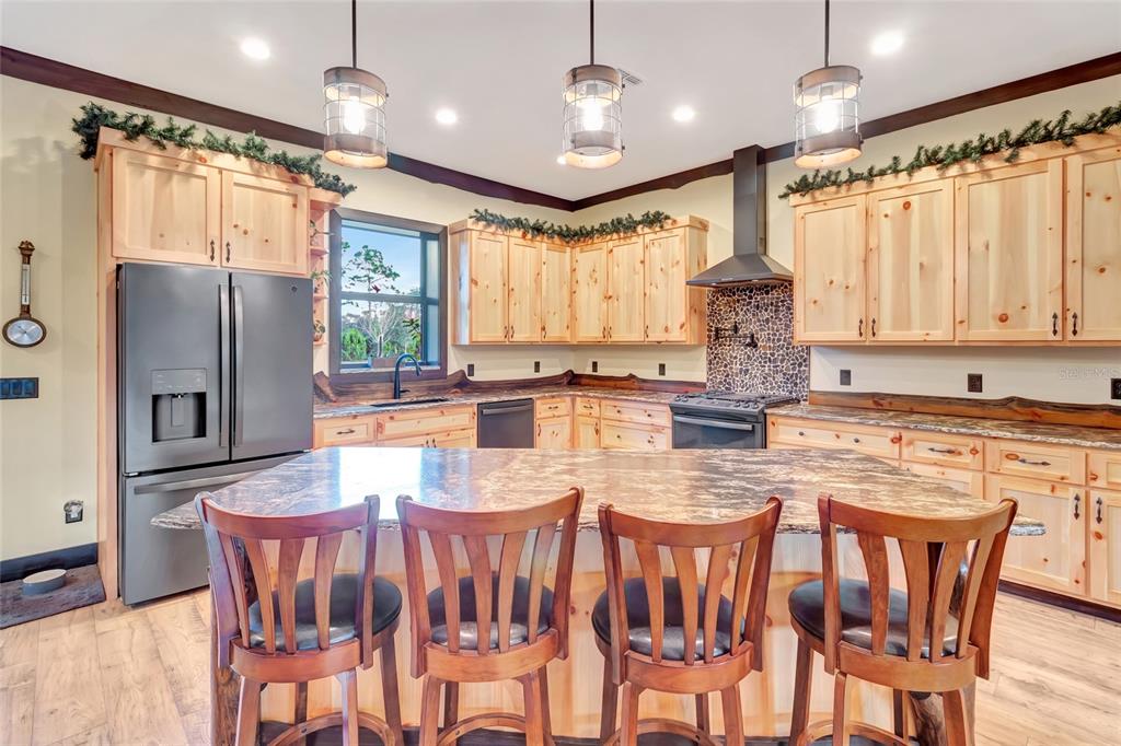 7330 Crabgrass Road St. Cloud, FL 34773 - Photo 10 of 60 a kitchen with stainless steel appliances granite countertop a stove a refrigerator a kitchen island and chairs