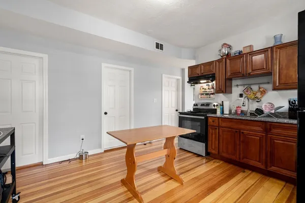 a kitchen with stainless steel appliances granite countertop a sink dishwasher and cabinets with wooden floor