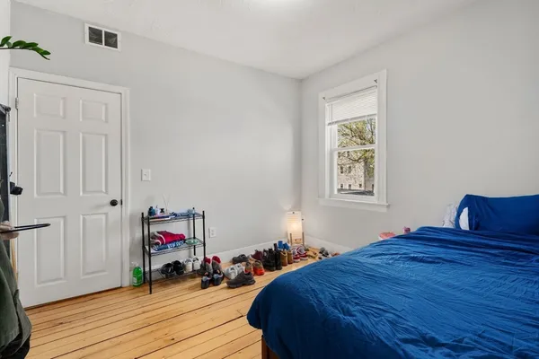 a bedroom with a bed and wooden floor