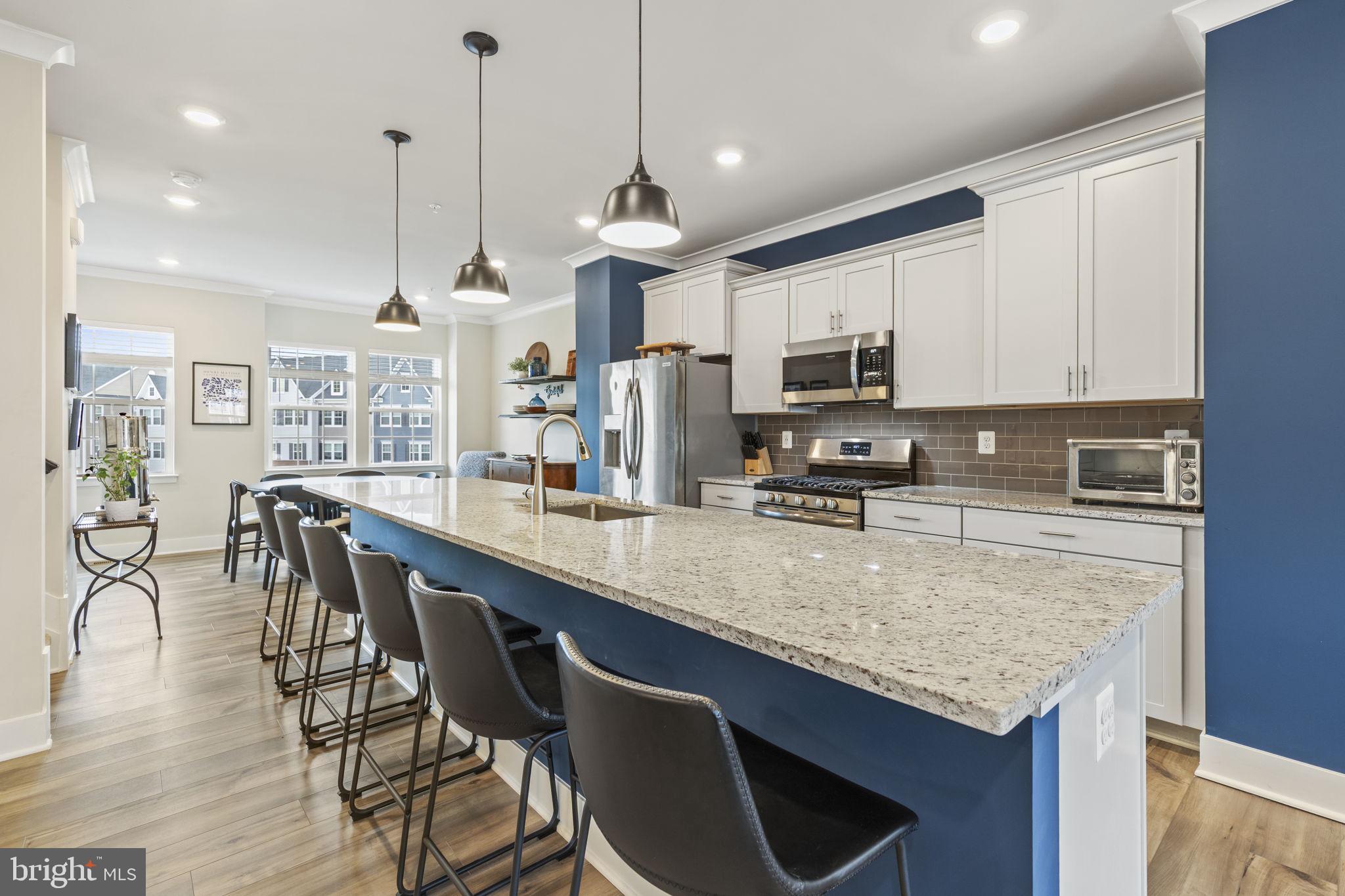 2045 Ivory Brook Road Baltimore, MD 21244 - Photo 5 of 39 a kitchen with stainless steel appliances granite countertop a stove a refrigerator a kitchen island a sink and a wooden cabinets