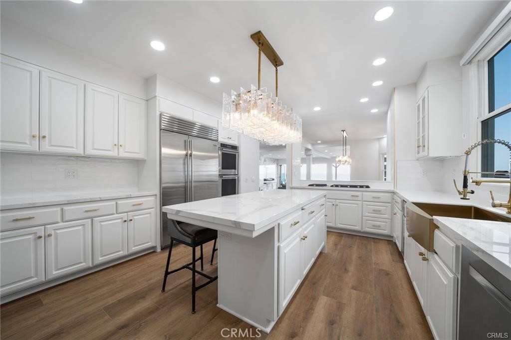 35555 Beach Road Dana Point, CA 92624 - Photo 21 of 68 a kitchen with kitchen island granite countertop a sink stainless steel appliances and white cabinets