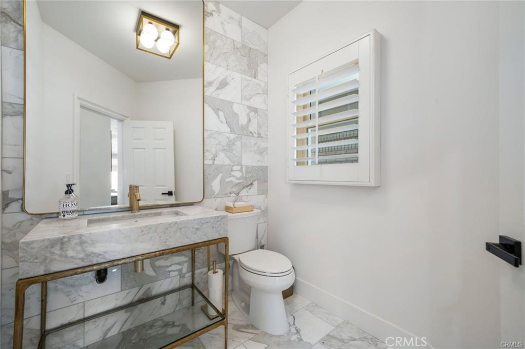 35555 Beach Road Dana Point, CA 92624 - Photo 35 of 68 a bathroom with a granite countertop toilet a sink and a mirror