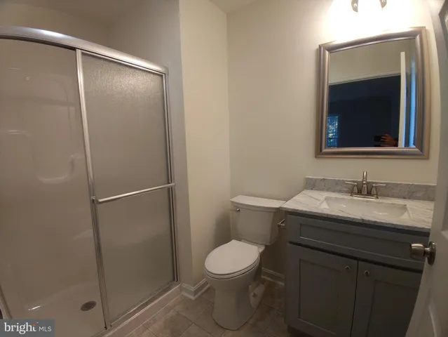 a bathroom with a granite countertop sink toilet and a mirror