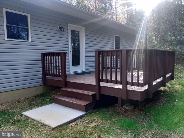 a view of a wooden bench sitting in backyard of house