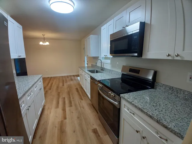 a kitchen with granite countertop a sink and a stove top oven