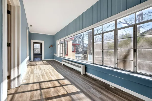 a view of a hallway with wooden floor and staircase