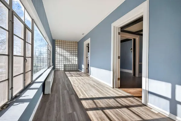 a view of a livingroom with wooden floor fireplace and windows