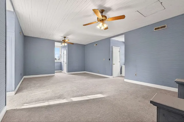 a view of an empty room with a ceiling fan