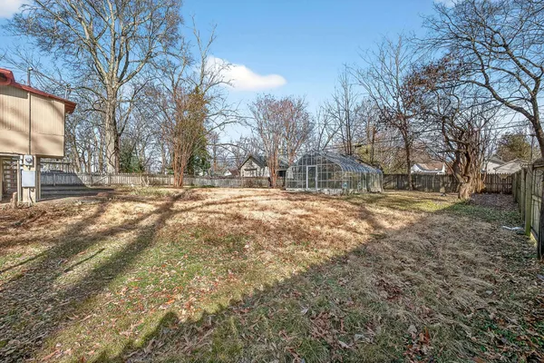 a big room with large trees and a wooden fence