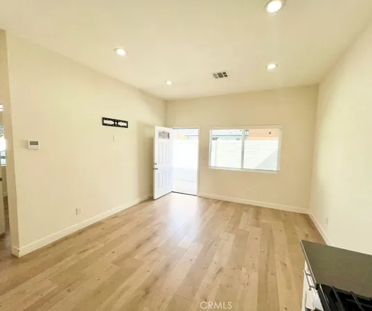 a view of an empty room with wooden floor