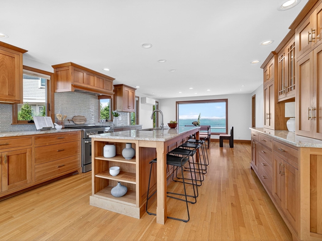57 Harborview Road Hull, MA 02045 - Photo 5 of 41 a kitchen with stainless steel appliances granite countertop a table chairs stove and a window