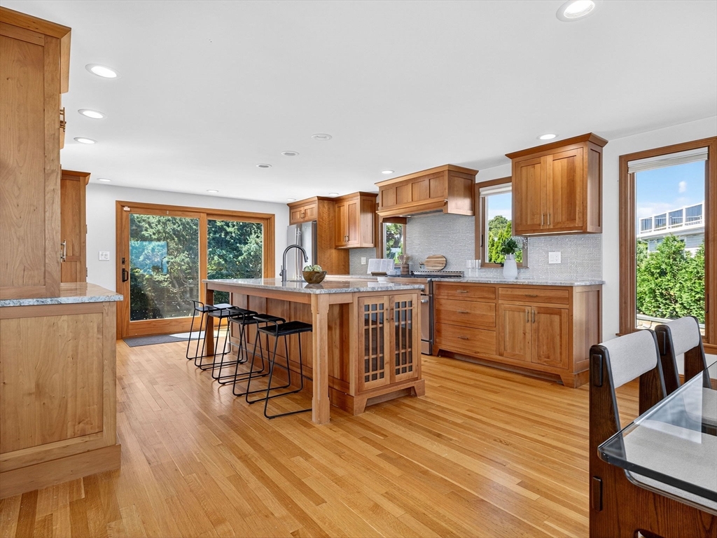 57 Harborview Road Hull, MA 02045 - Photo 7 of 41 a kitchen with stainless steel appliances wooden floors and wooden cabinets