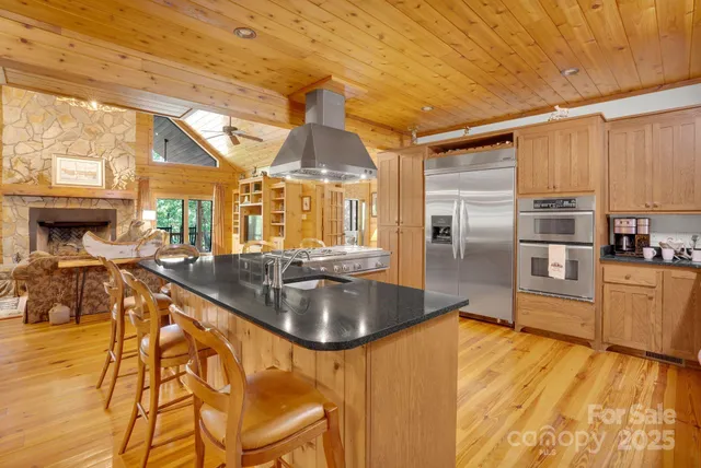 a kitchen with stainless steel appliances granite countertop a sink a stove and refrigerator
