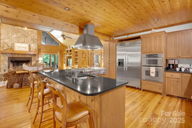 a kitchen with stainless steel appliances granite countertop a sink a stove and refrigerator