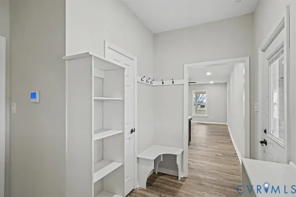 a view of a hallway with wooden floor and closet