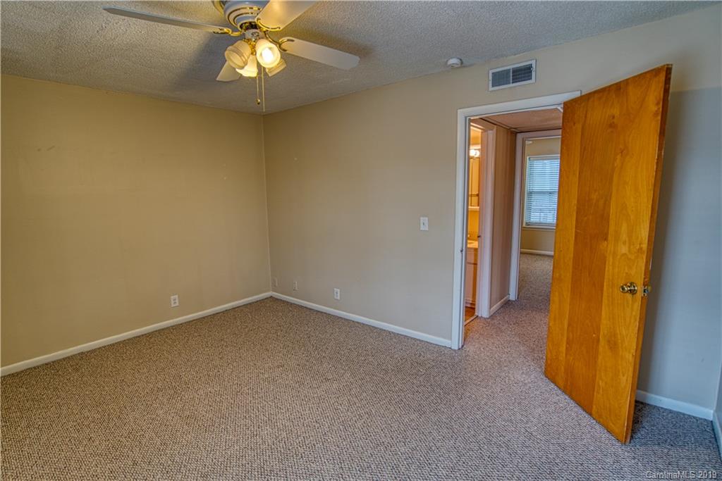 2616 Park Road, Unit H Charlotte, NC 28209 - Photo 13 of 28 an empty room with windows and chandelier fan