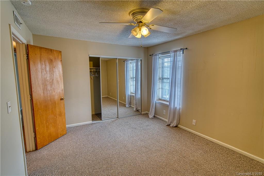 2616 Park Road, Unit H Charlotte, NC 28209 - Photo 23 of 28 an empty room with a ceiling fan and a window