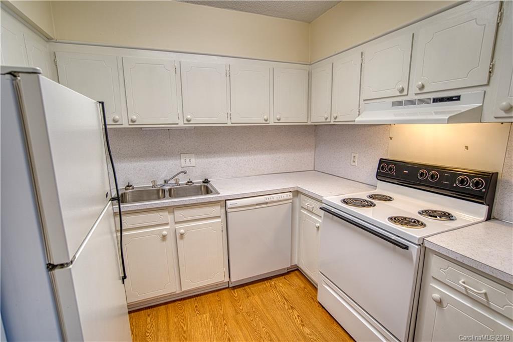 2616 Park Road, Unit H Charlotte, NC 28209 - Photo 9 of 28 a kitchen with white cabinets and white appliances