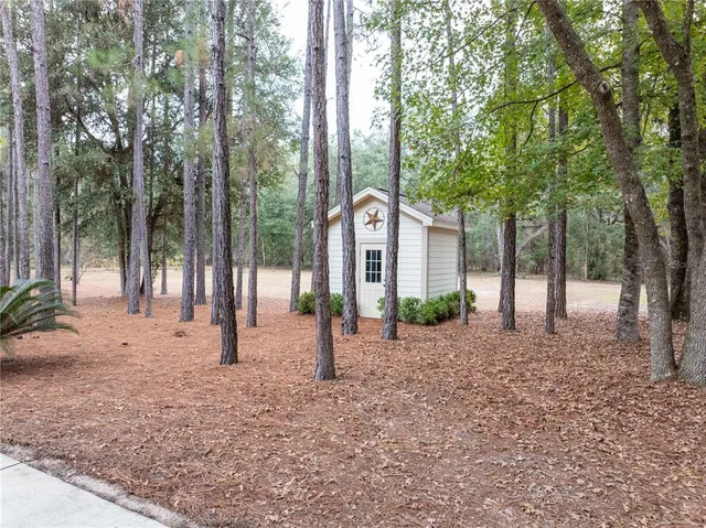 an aerial view of a house with a yard and large trees