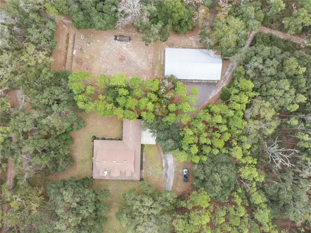 a view of a house with a big yard and large trees