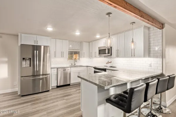a kitchen with appliances cabinets a sink and a stove
