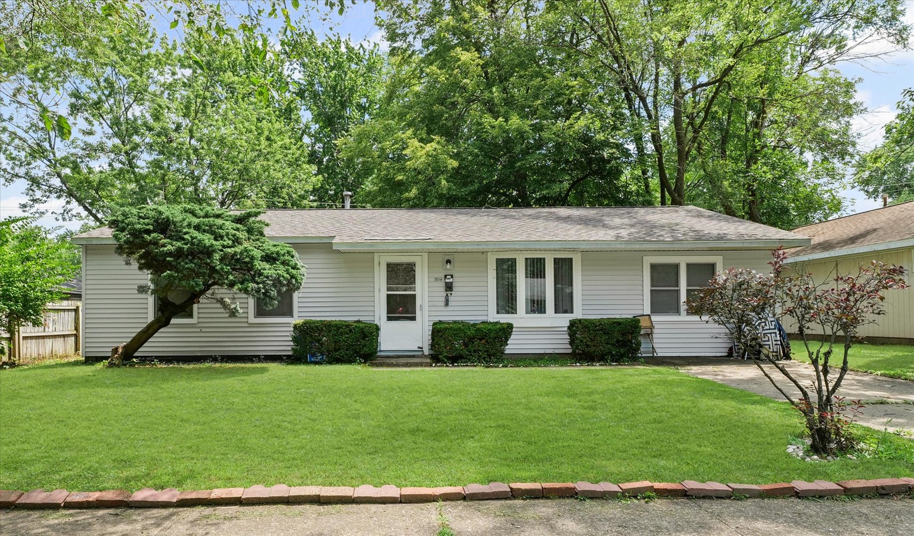 a front view of a house with a yard and trees