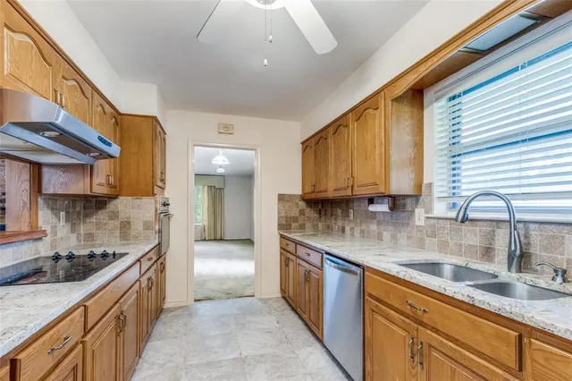 a large kitchen with stainless steel appliances granite countertop a sink stove and cabinets