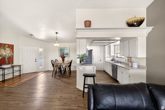 161 West 950 South, Unit Q1 St. George, UT 84770 - Photo 8 of 37 Kitchen featuring light countertops, white cabinetry, dark wood-type flooring, a kitchen breakfast bar, and stainless steel appliances