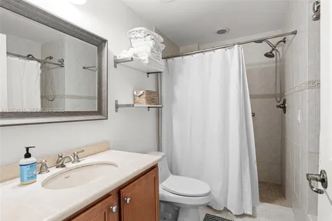 a bathroom with a sink toilet mirror and shower