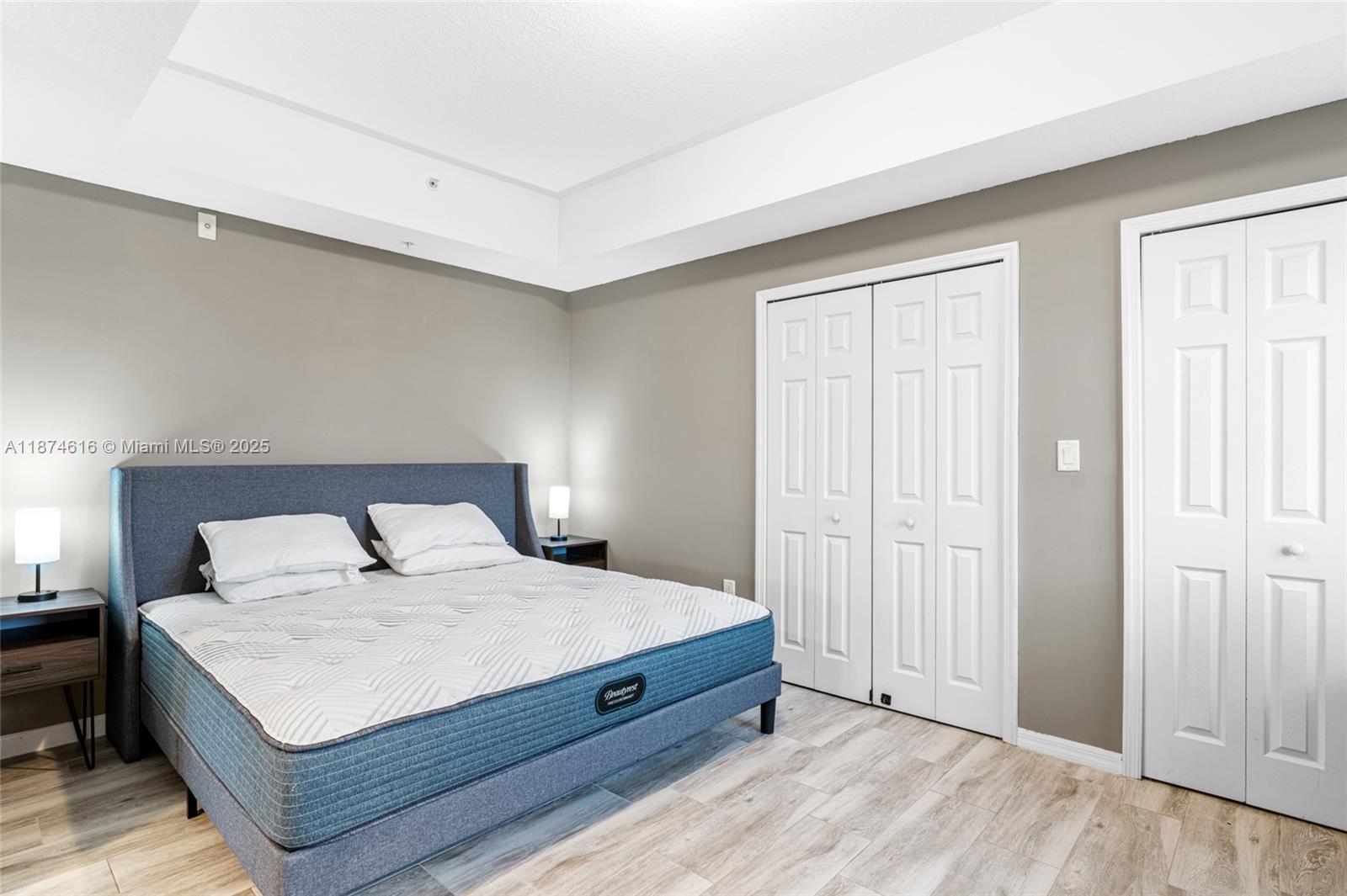 5271 Southwest 8th Street, Unit 315 Miami, FL 33134 - Photo 14 of 26 a large bedroom with a bed and wooden floor