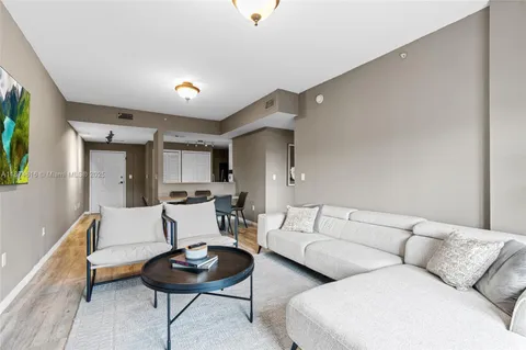 a living room with furniture and a wooden floor